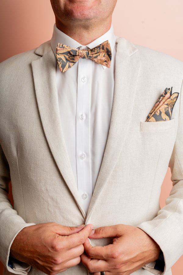 Bow tie featuring a detailed Byron Banksia print with intricate green, orange, and brown leaves and flowers on a dark background, highlighting the unique beauty of this native Australian flora