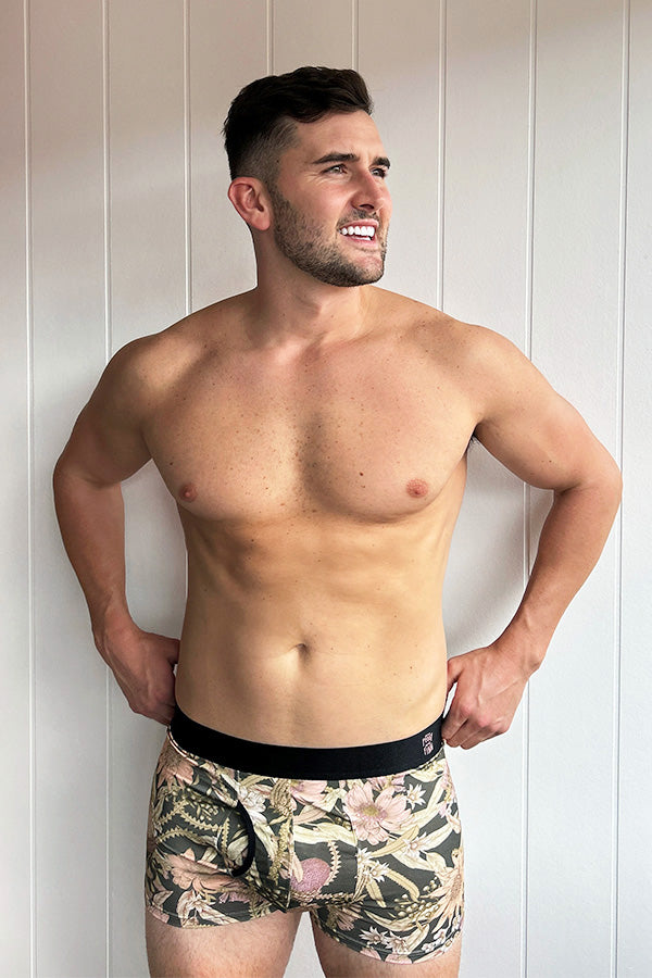 Men&#39;s bamboo underwear featuring a charcoal base with Banksia and Waratah prints in peach and pink tones